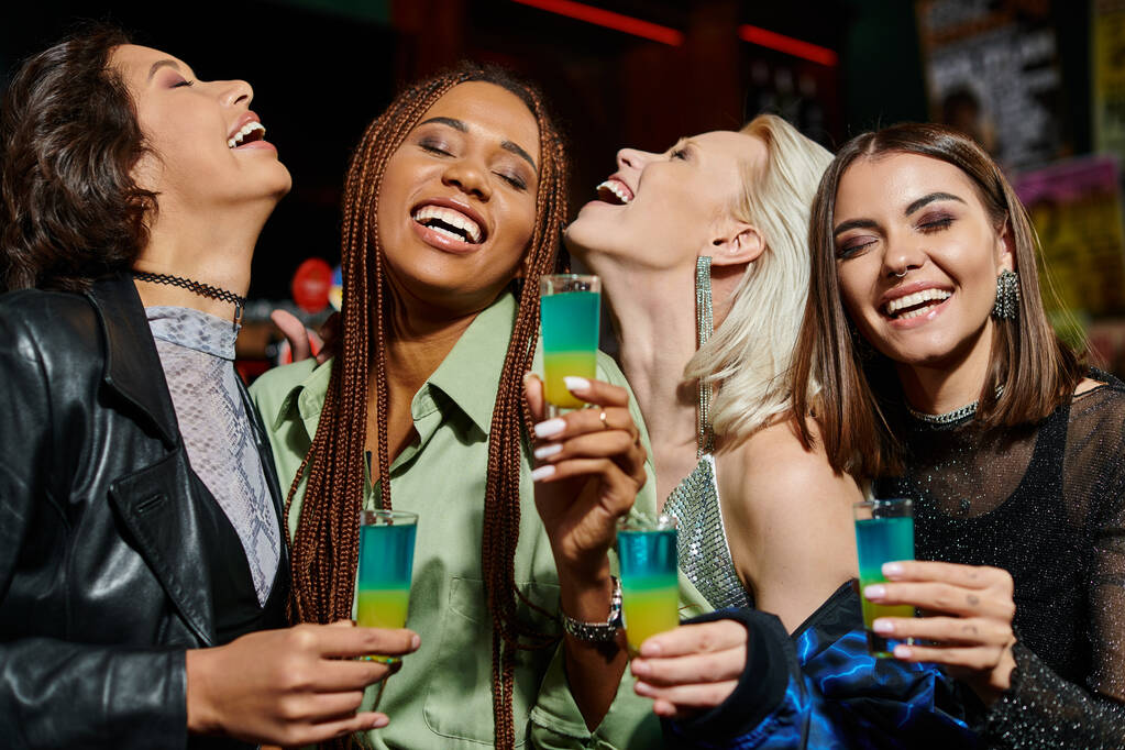Bardaki partide gözleri kapalı gülümseyen shot bardaklı mutlu çok kültürlü kız arkadaşlar. - Fotoğraf, Görsel