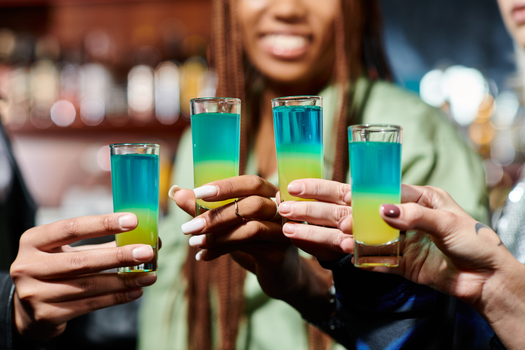 recortado vista de feliz multiétnico amigos hembras tintineo vasos de chupito en el bar, tiempo de fiesta - Foto, Imagen