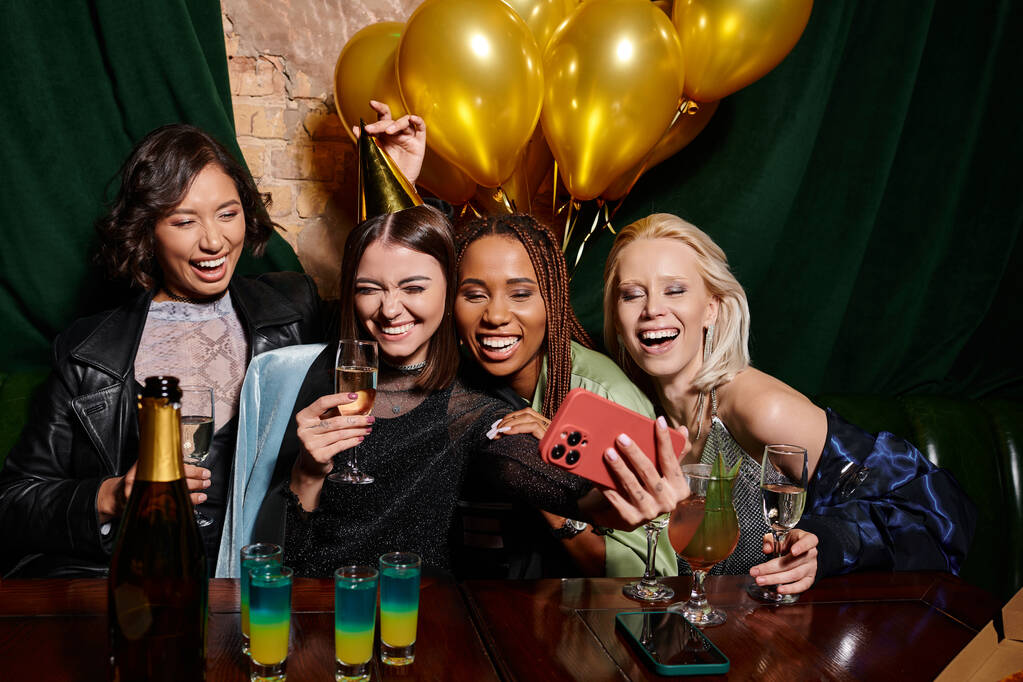 novias multiculturales emocionadas con champán tomando selfie en el teléfono inteligente en el bar, fiesta de cumpleaños - Foto, imagen
