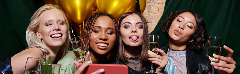 весёлые мультиэтнические женщины с шампанским гримасируют и делают селфи на мобильном телефоне в баре, баннер - Фото, изображение