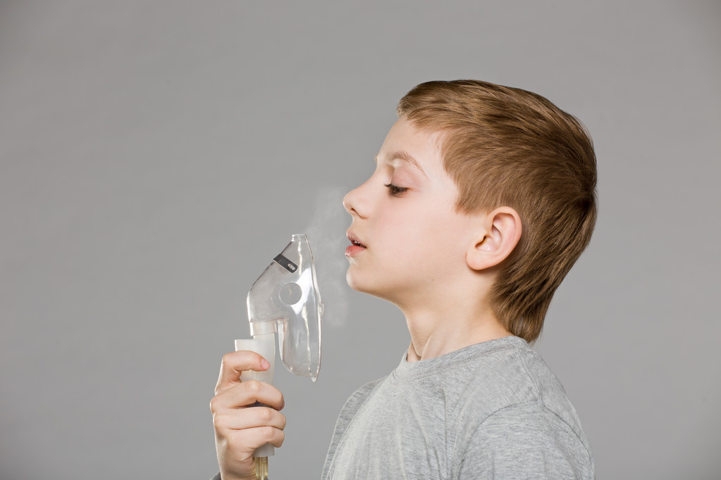 Jongen ademhaling van inhalator masker vrijgeven van rook op grijs backgr - Foto, afbeelding