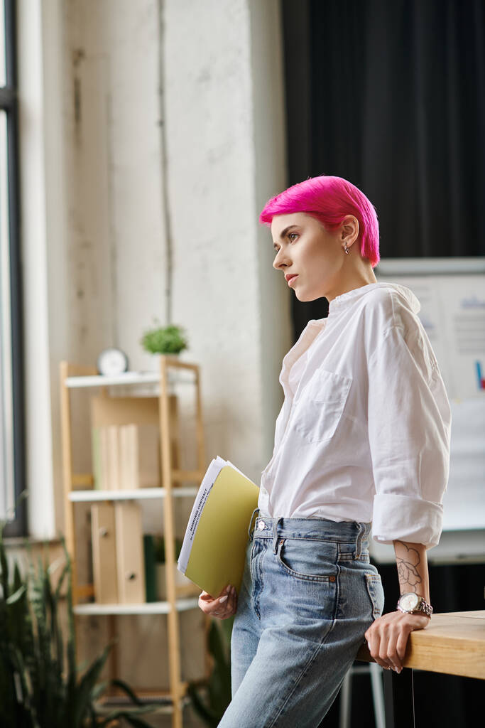 joven bonita mujer de negocios con el pelo corto rosa posando con sus notas en la mano y mirando hacia otro lado - Foto, Imagen