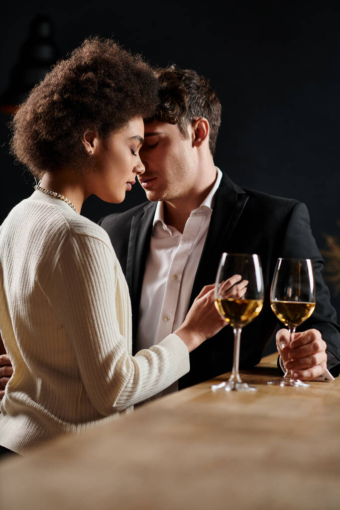 若い異人種間のカップルは,バレンタインデーの日にワインのメガネの近くで素晴らしい時間を過ごしました - 写真・画像