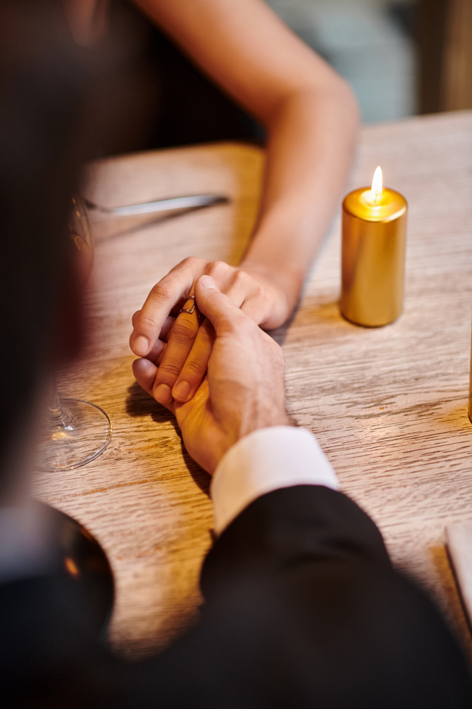 バレンタインデーのレストランでロマンチックなディナー中に女性の手を保持する男性のクロップビュー - 写真・画像
