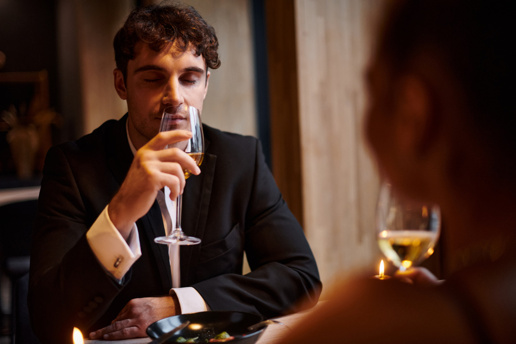 handsome man drinking white wine near girlfriend during date on Valentines day, romantic dinner - Photo, Image