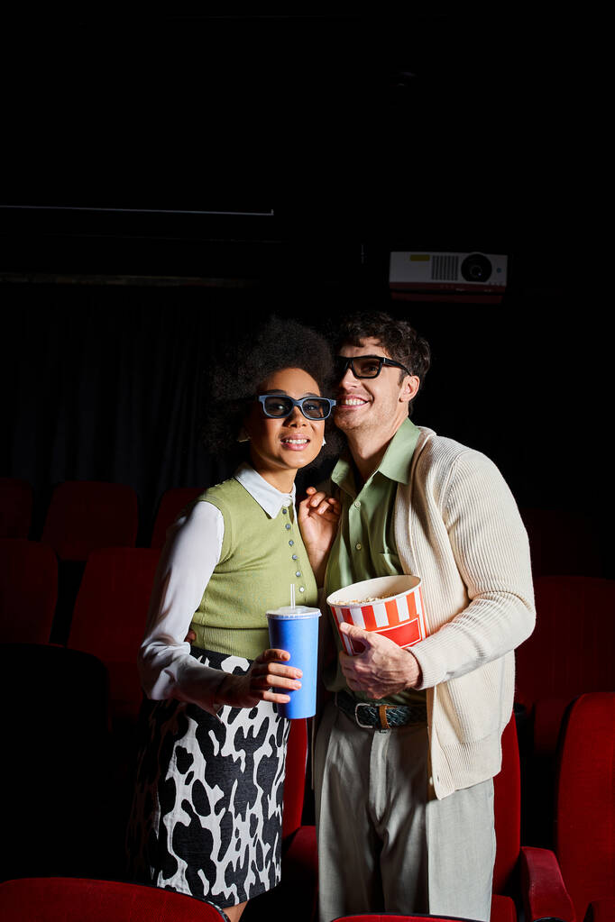 iloinen monikulttuurinen pari, jolla on 3D-lasit retro-asuissa kameran edessä, Ystävänpäivä - Valokuva, kuva