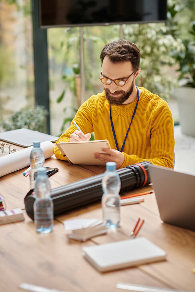 fókuszált jóképű férfi alkalmi sárga garbó dolgozik a startup, míg az irodában - Fotó, kép