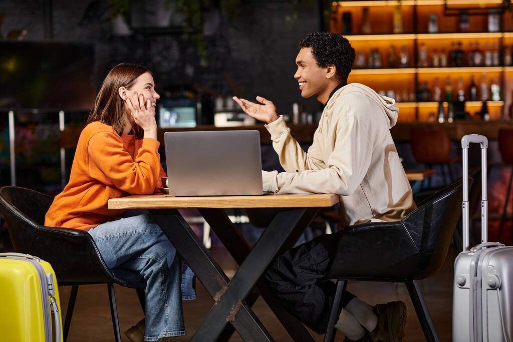 Разнообразная пара, работающая над проектом вместе, черный мужчина и женщина сидят за столом с ноутбуком - Фото, изображение