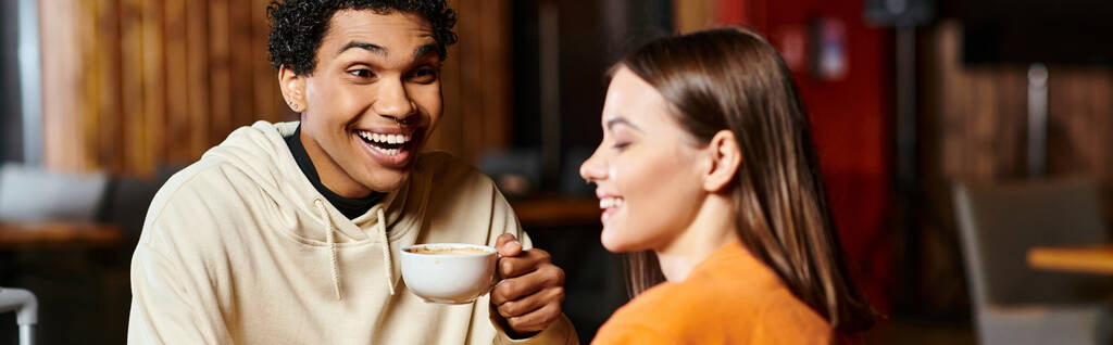 Ilık kahvesini yudumlayan bir adam, şık kız arkadaşı afiş ile aynı gülümsemeyi paylaşır. - Fotoğraf, Görsel