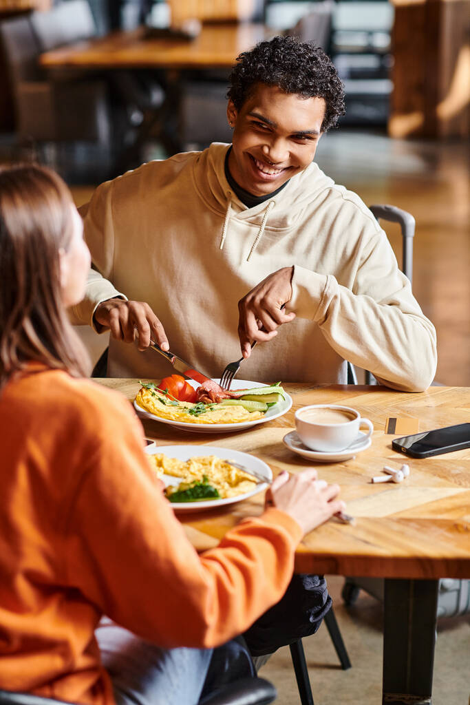 feliz pareja comparte un momento tranquilo juntos, ya que disfrutan de un almuerzo caliente en la comodidad de la acogedora cafetería - Foto, Imagen