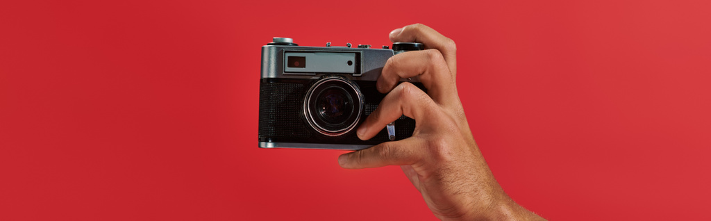 bannière recadrée du photographe afro-américain prenant des photos sur caméra rétro sur fond rouge - Photo, image