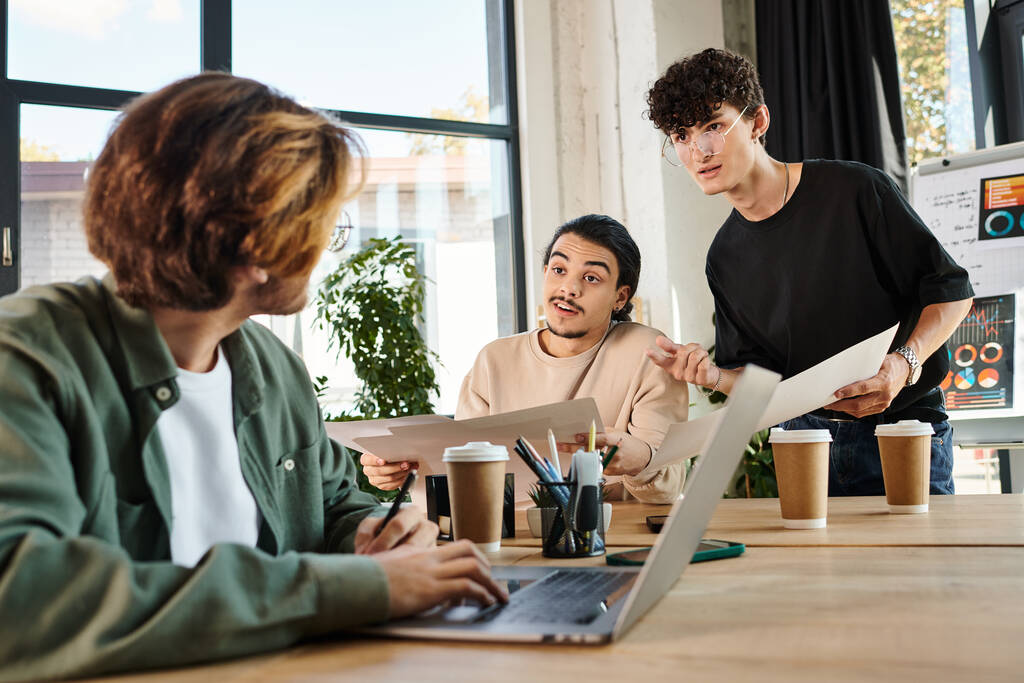 Equipe de jovens empresários envolvidos no planejamento de projetos em um escritório brilhante, homem borrado perto de laptop - Foto, Imagem