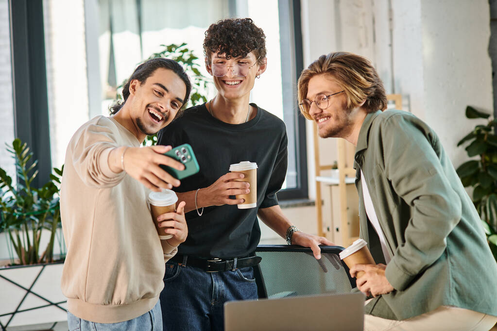 Mladí podnikatelé si vychutnávají přestávku na kávu a dávají si selfie v pracovním prostoru, muži kolem dvaceti - Fotografie, Obrázek
