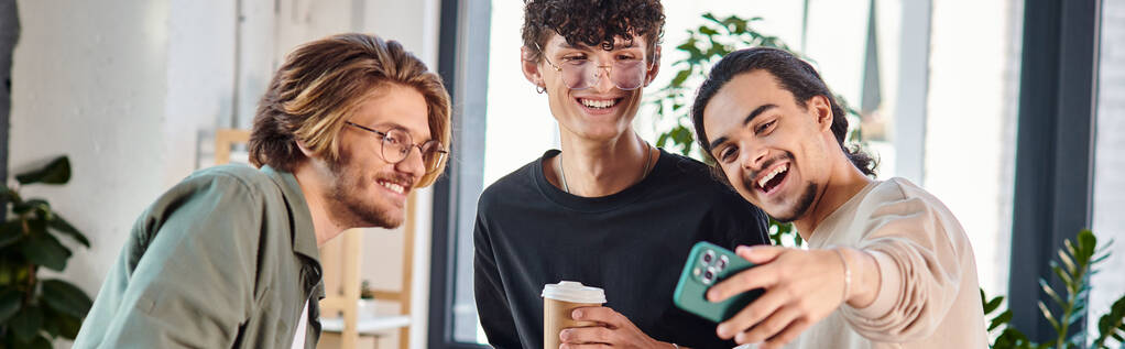 Young businessmen enjoying a coffee break and taking a selfie in a coworking space, banner - Photo, Image