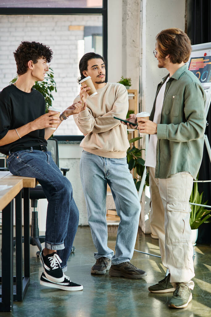 молоді чоловіки в 20-х роках діляться ідеями і тримають каву, щоб піти в сучасний офіс, стартап команда - Фото, зображення