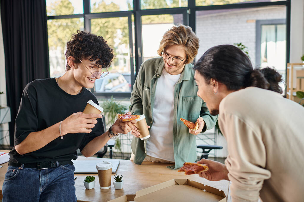 homens sorridentes desfrutando de uma pizza em um ambiente amigável e descontraído, equipe de inicialização que almoça - Foto, Imagem