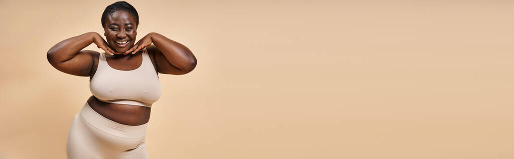 szczęśliwy plus rozmiar afrykański amerykański kobieta z rękami w pobliżu jej twarz na pasujące tło, sztandar - Zdjęcie, obraz