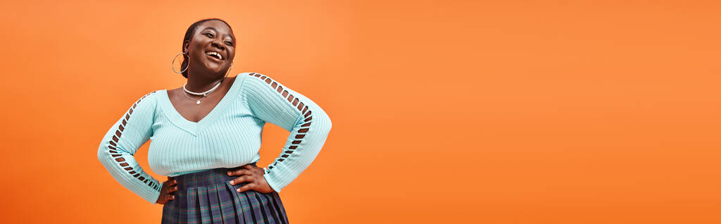 gai plus la taille femme afro-américaine en bleu manches longues posant avec les mains sur les hanches, bannière - Photo, image