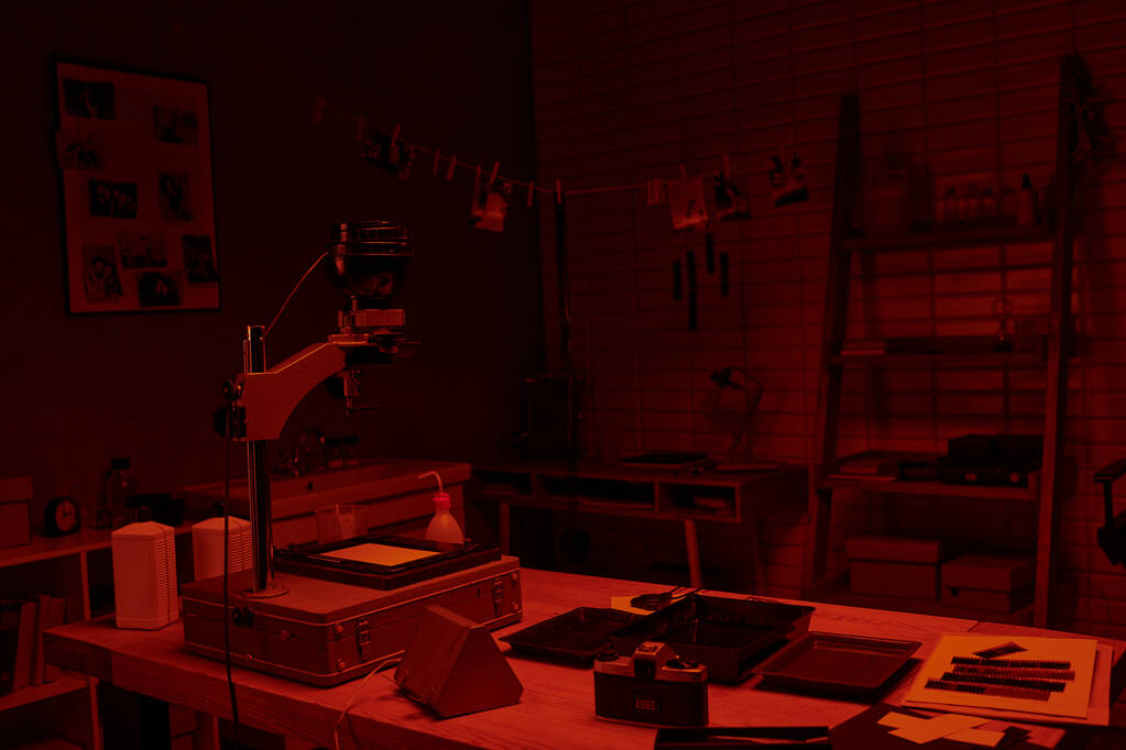 donkere kamer interieur met rood licht, presentatie van het proces van filmontwikkeling en fotografie kunst - Foto, afbeelding