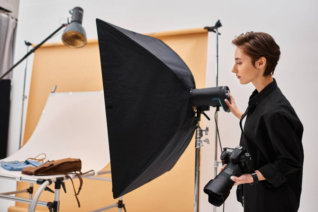 splendida bruna fotografa femminile in abiti di tutti i giorni che lavora con la sua attrezzatura in studio - Foto, immagini