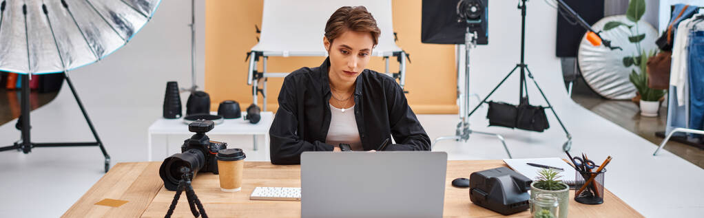 fotógrafo feminino atraente em traje casual trabalhando no laptop com xícara de café na mesa, banner - Foto, Imagem