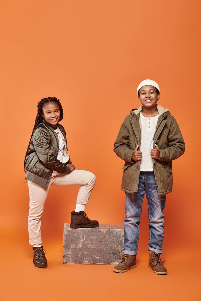 vidám afro-amerikai gyerekek téli ruhák pózol díszítés háttér és mosolyogva boldogan - Fotó, kép