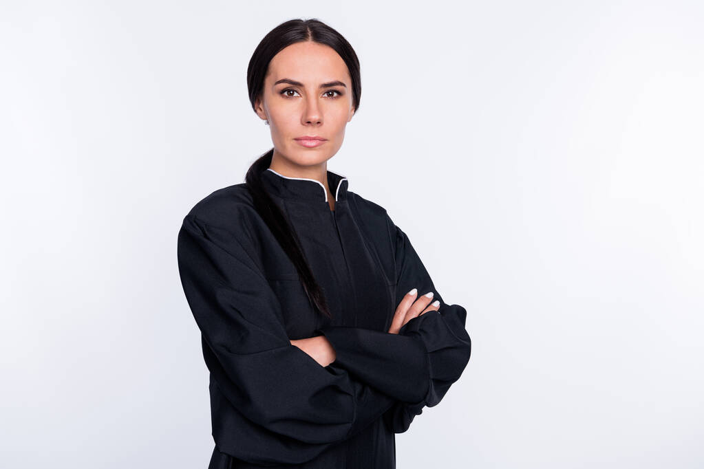 Zdjęcie poważnej pewności siebie piękna kobieta adwokat ze złożonymi rękami nosić czarny szlafrok izolowane na białym tle koloru. - Zdjęcie, obraz