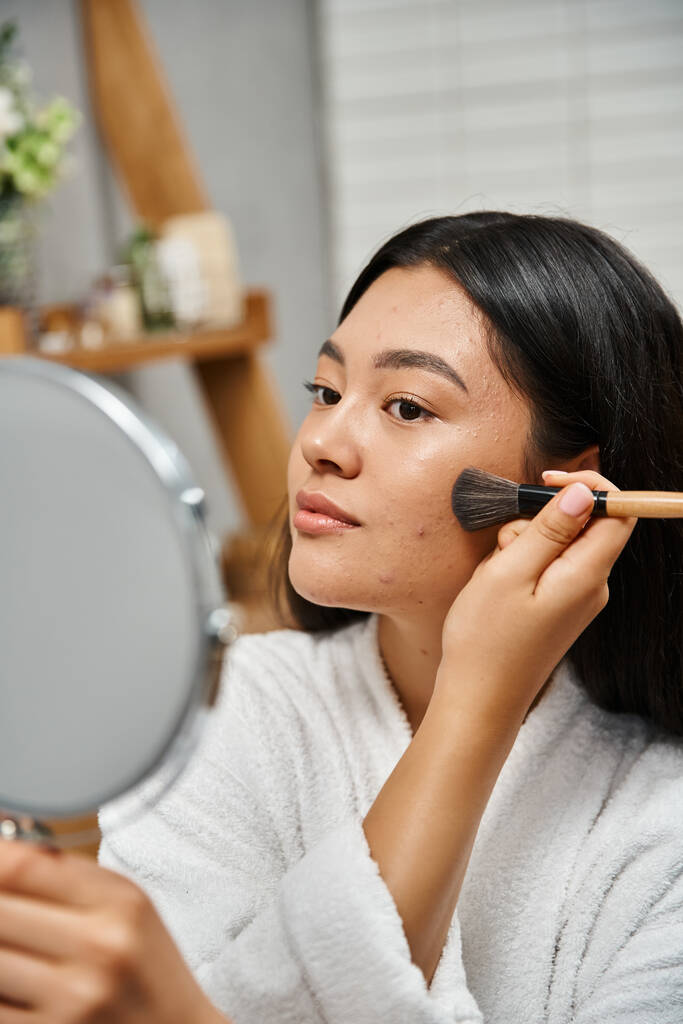 молодая азиатка с брюнетками и прыщами на коже наносит порошок для лица, кожные проблемы и макияж - Фото, изображение
