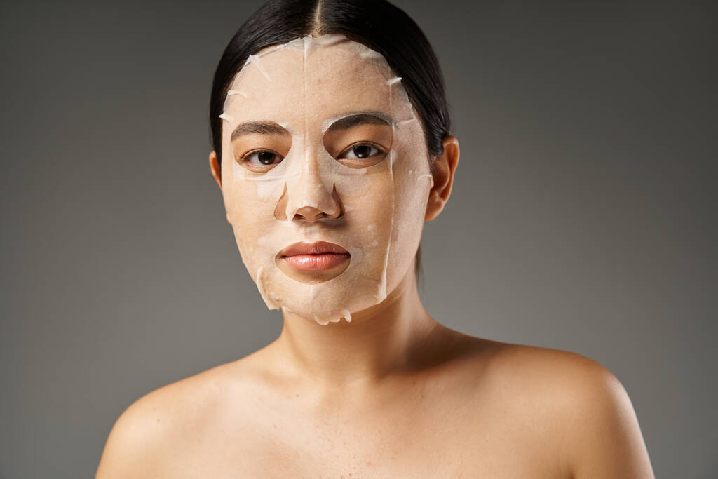 jonge aziatische vrouw met brunette haar en acne gevoelige huid op zoek naar spiegel in de badkamer, banner - Foto, afbeelding