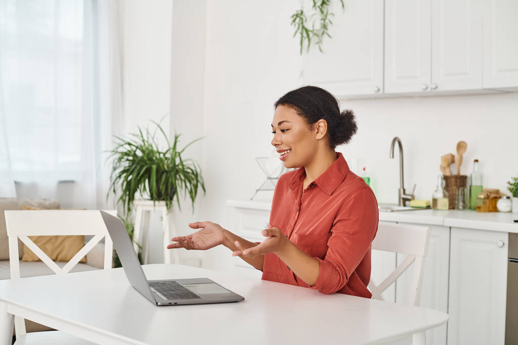 vrolijke vrouwelijke voedingsdeskundige het verstrekken van online overleg tijdens het werken op afstand van haar keuken - Foto, afbeelding