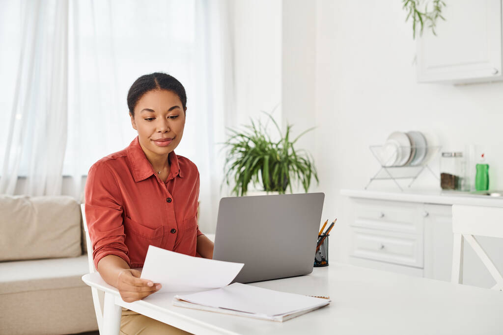 Nutricionista afro-americano revisando documentos perto de laptop para consulta on-line em casa - Foto, Imagem