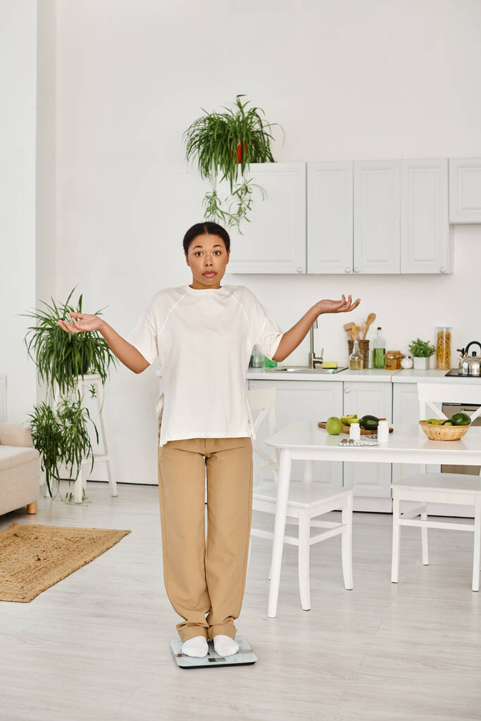 zavaros fekete nő alkalmi öltözékben álló skálán a konyhában, fogyás rutin - Fotó, kép
