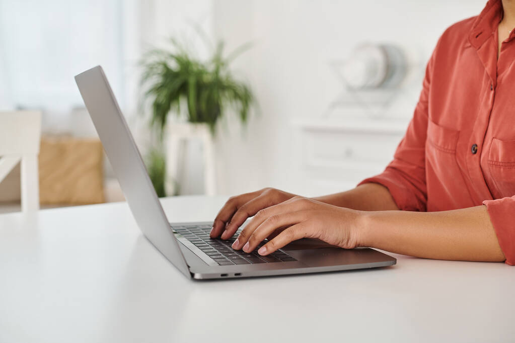 bijgesneden foto van Afrikaanse Amerikaanse diëtist met behulp van haar laptop tijdens het typen en werken vanuit huis - Foto, afbeelding