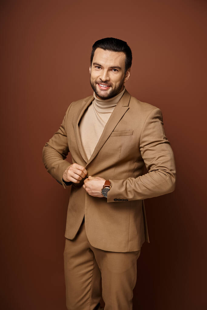ritratto di uomo sicuro e di bell'aspetto con setole in abito elegante in posa su sfondo beige - Foto, immagini
