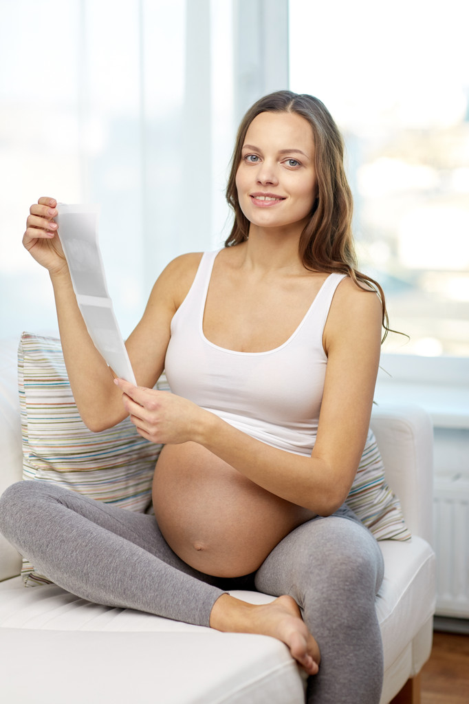 Szczęśliwa kobieta w ciąży z USG obraz w domu - Zdjęcie, obraz