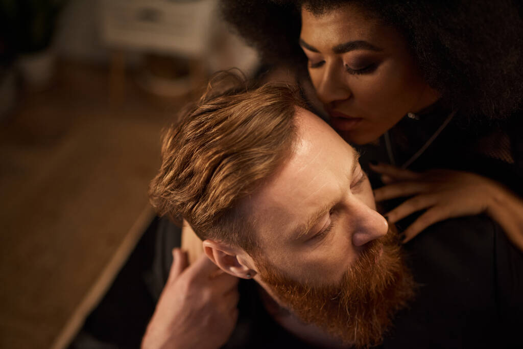 noite apaixonada de casal diversificado em casa, encaracolado Africano americano mulher beijando tatuado homem - Foto, Imagem