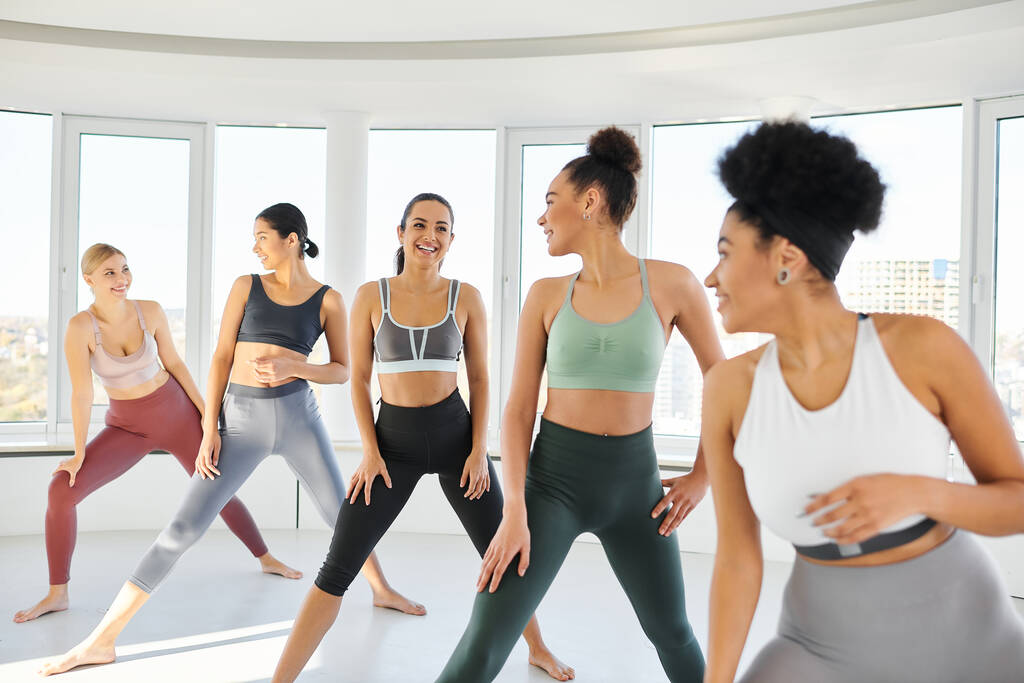 skupina šťastných různorodých žen ve sportovním oblečení cvičit pilates s ženou africký americký trenér - Fotografie, Obrázek