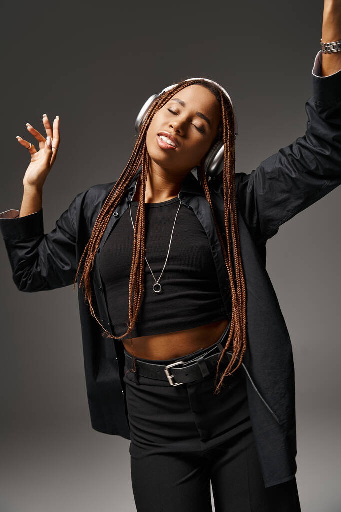 young african american woman in 20s with dreadlocks listening music in headphones, ecstatic dance - Photo, Image