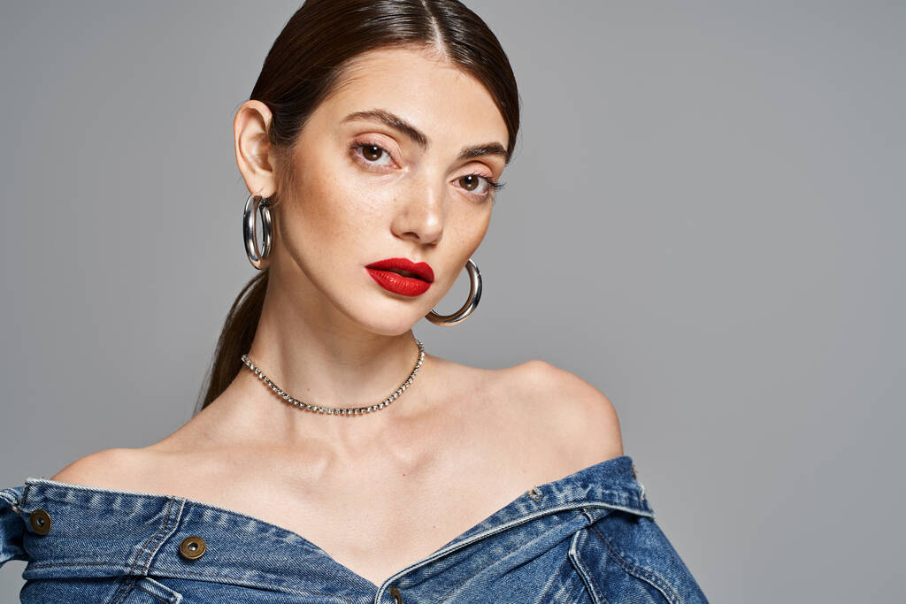 A stylish young woman with brunette hair wearing a denim dress and bright red lipstick. - Photo, Image