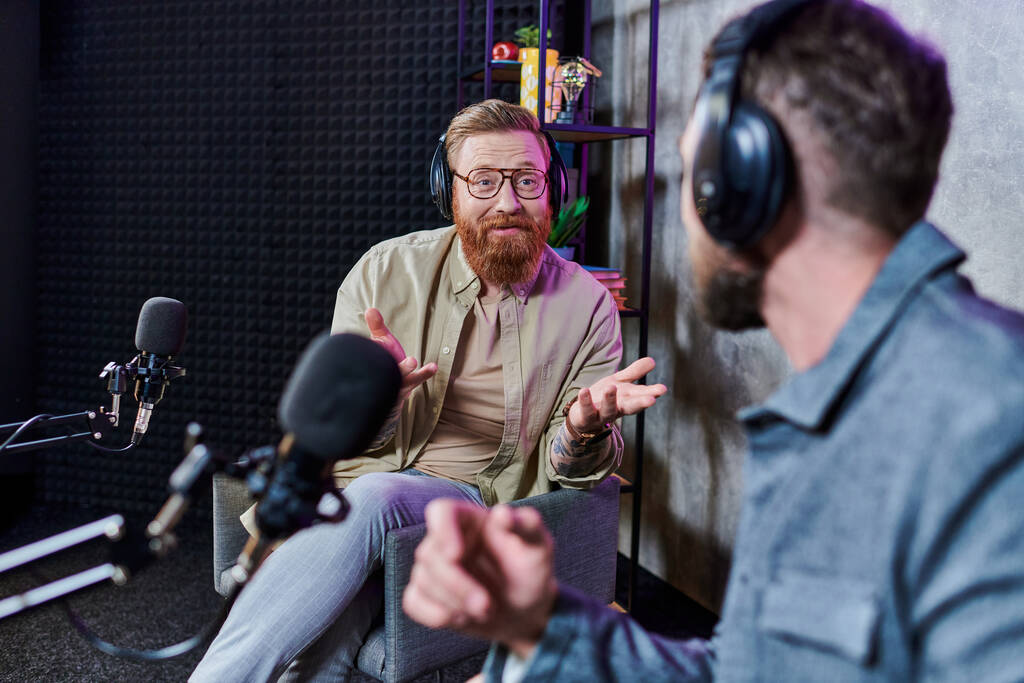 бородатий красивий інтерв'юер і його гість з навушниками в студії обговорюють питання, подкаст - Фото, зображення