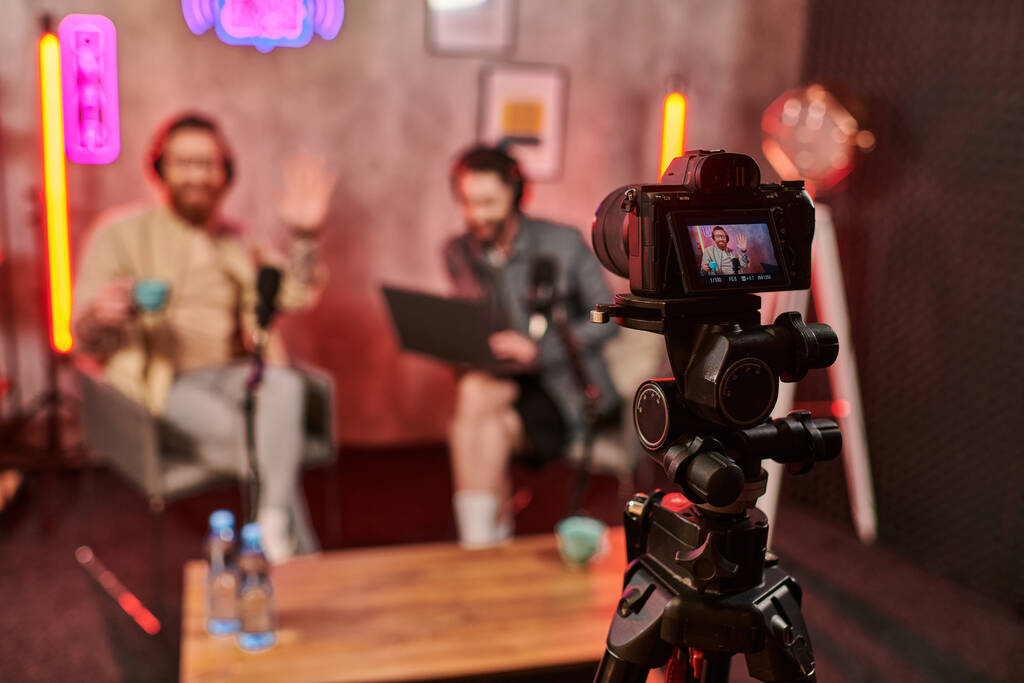 focus on camera filming stylish blurred men with beards in headphones discussing questions - Photo, Image