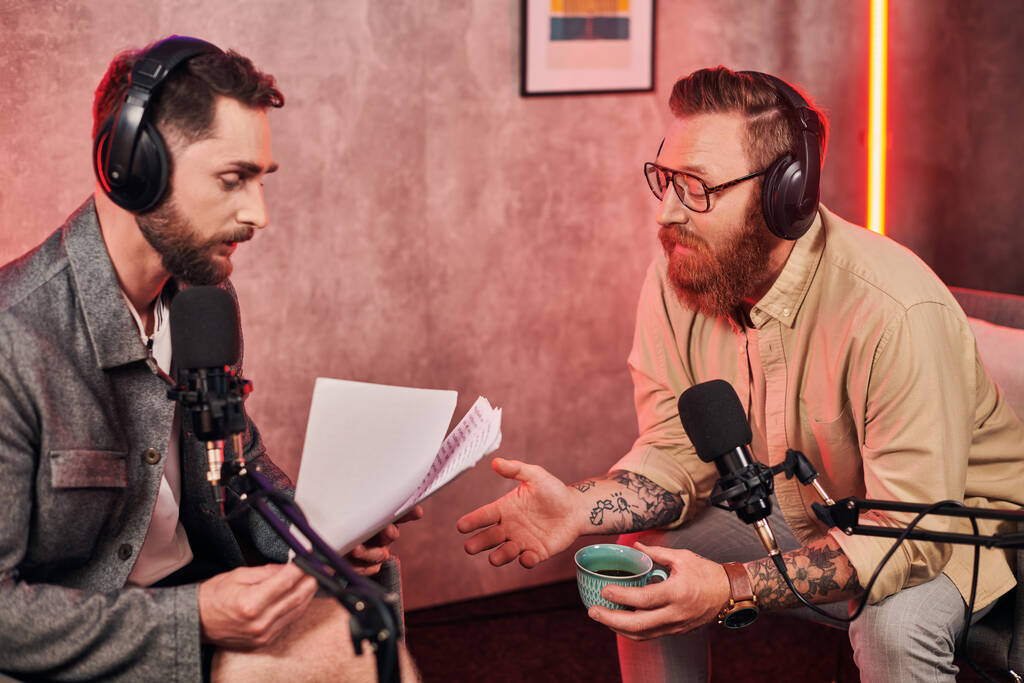 good looking men in casual comfortable attires with headphones discussing questions during podcast - Photo, Image