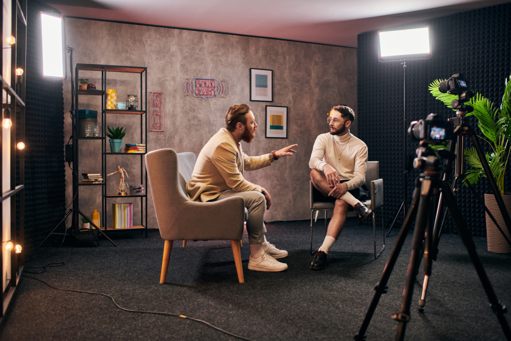 attrayant hommes élégants dans des vêtements élégants assis et discuter des questions d'entrevue en studio - Photo, image