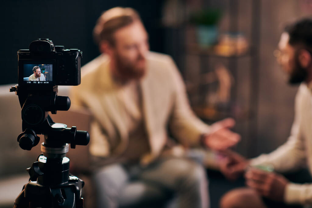 zaměření na kameru natáčení elegantní rozmazané muže s vousy v elegantním oblečení diskutovat otázky - Fotografie, Obrázek