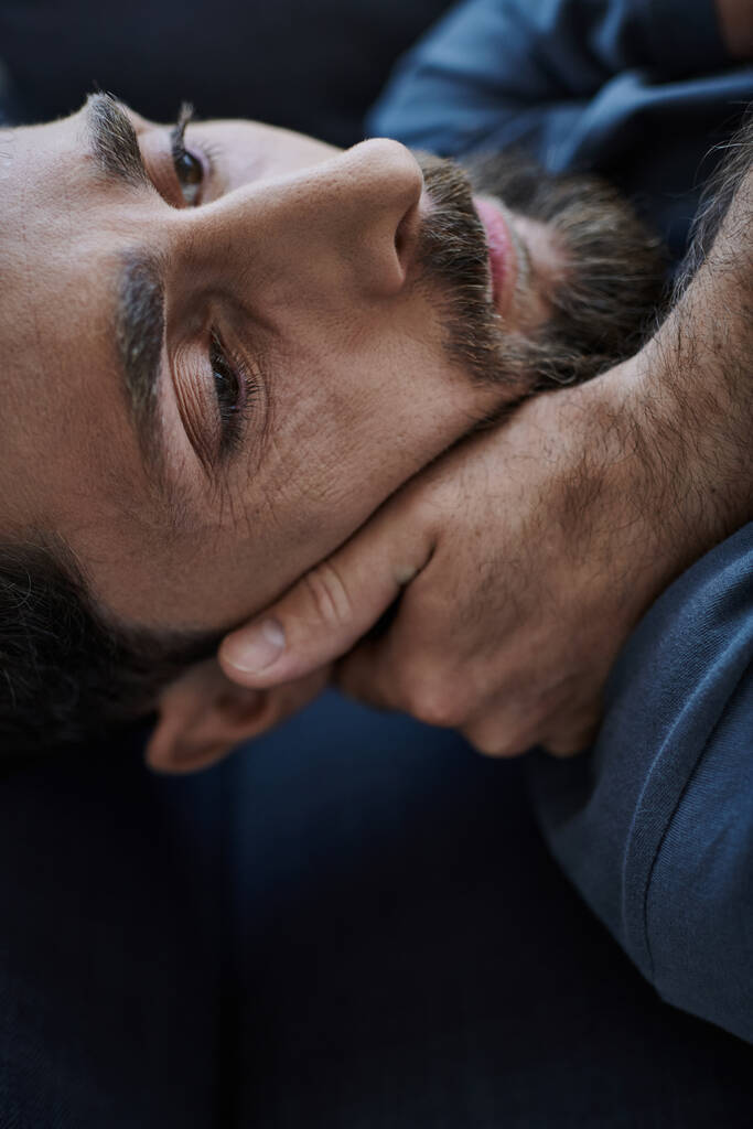 hombre barbudo deprimido en traje casual acostado en el sofá durante la ruptura, conciencia de la salud mental - Foto, imagen