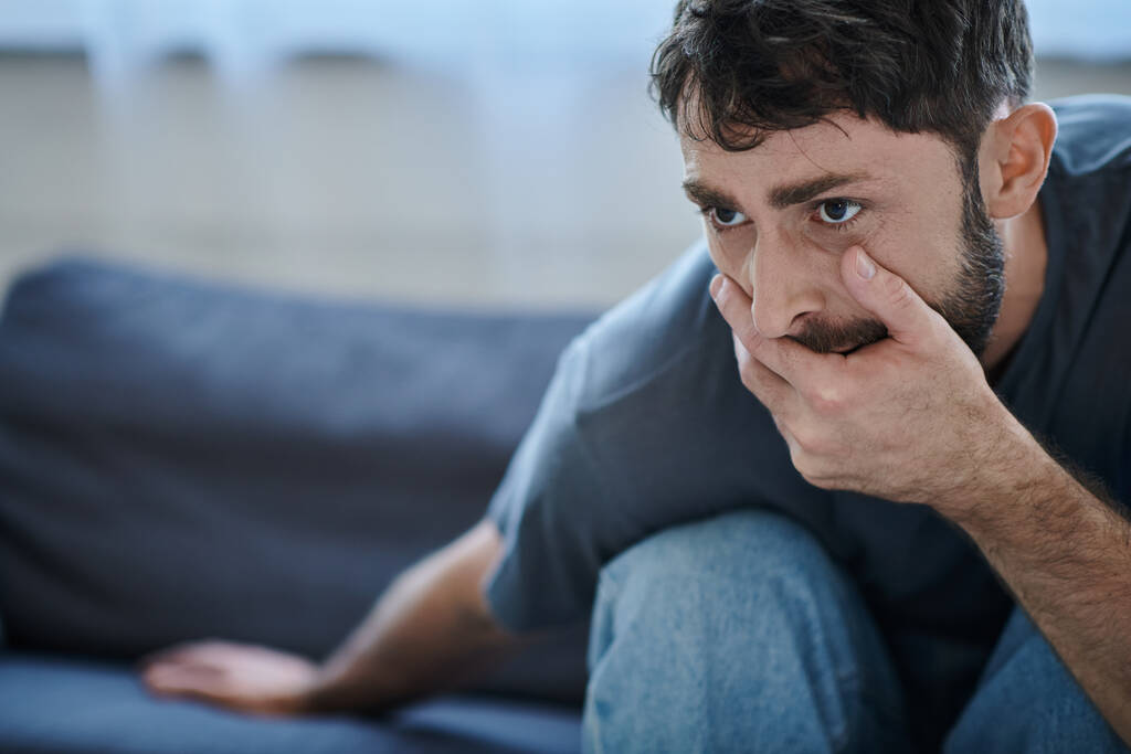 αγχωμένος άντρας με καθημερινά μπλουζάκια που κλείνει το στόμα του κατά τη διάρκεια καταθλιπτικού επεισοδίου, συνειδητοποίηση ψυχικής υγείας - Φωτογραφία, εικόνα