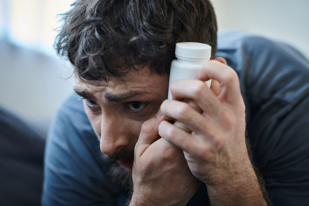 відчайдушний чоловік тримає таблетки під час депресивного епізоду з власною шкодою, обізнаністю про психічне здоров'я - Фото, зображення