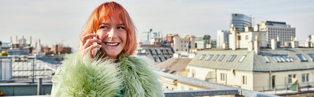 iloinen trendikäs nainen puhuu älypuhelimella ja katselee pois kattoterassilla Wienissä, banneri - Valokuva, kuva