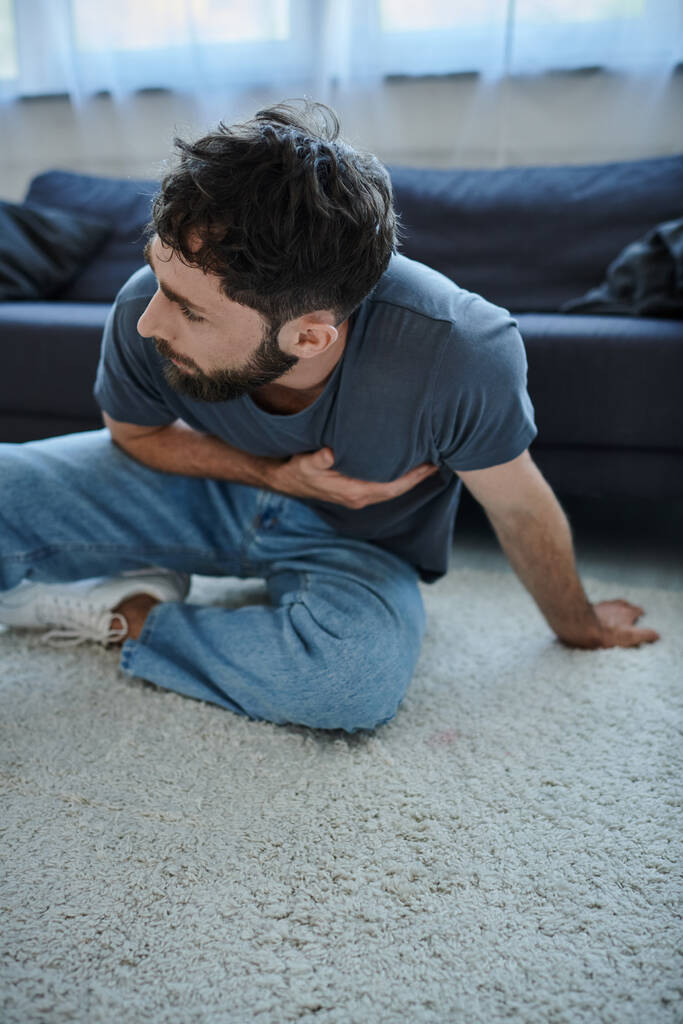 brodaty cierpiący mężczyzna w luźnym ubraniu domowym o ciężkim ataku paniki, świadomości zdrowia psychicznego - Zdjęcie, obraz
