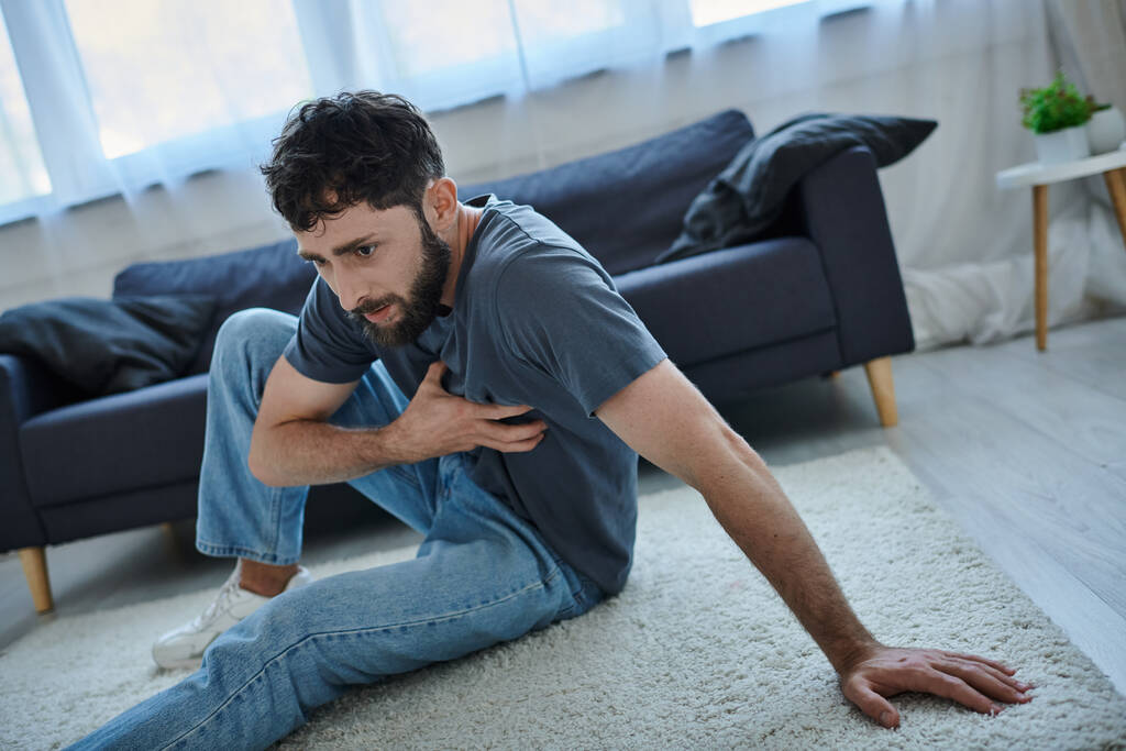 depresivní traumatizovaný muž s plnovousem v domácím oblečení s těžkou panikou záchvat, duševní zdraví vědomí - Fotografie, Obrázek